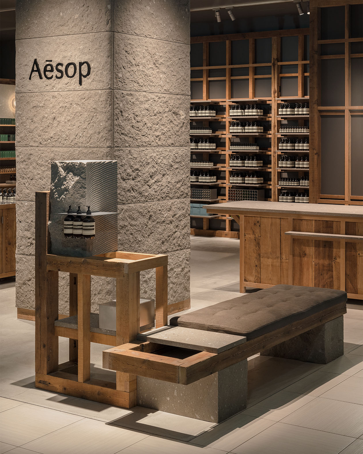 A bench made from reclaimed timber fragments next to the solid blocks of Sapporo Nanseki stone