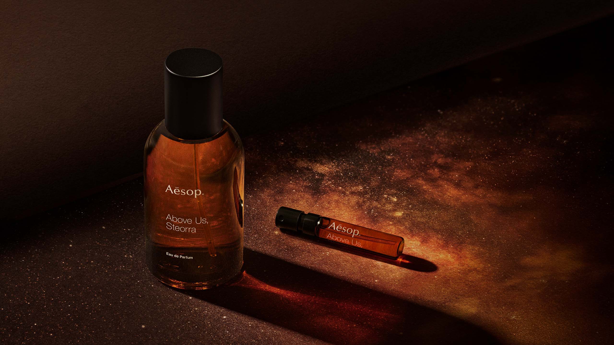 Above us steorra EDP bottle placed next to a 2mL sample vial