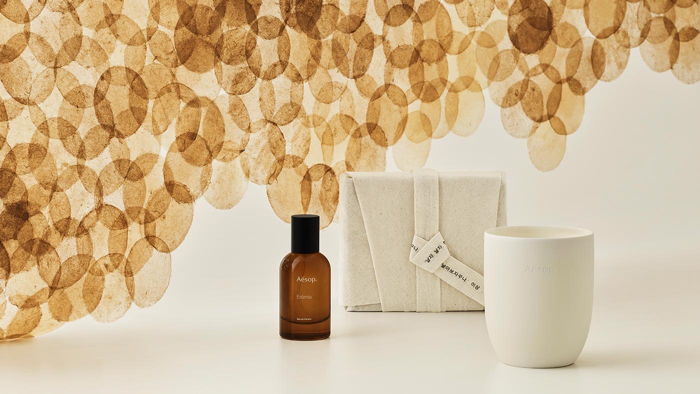 Aesop bottles with a background of white with cut out circles