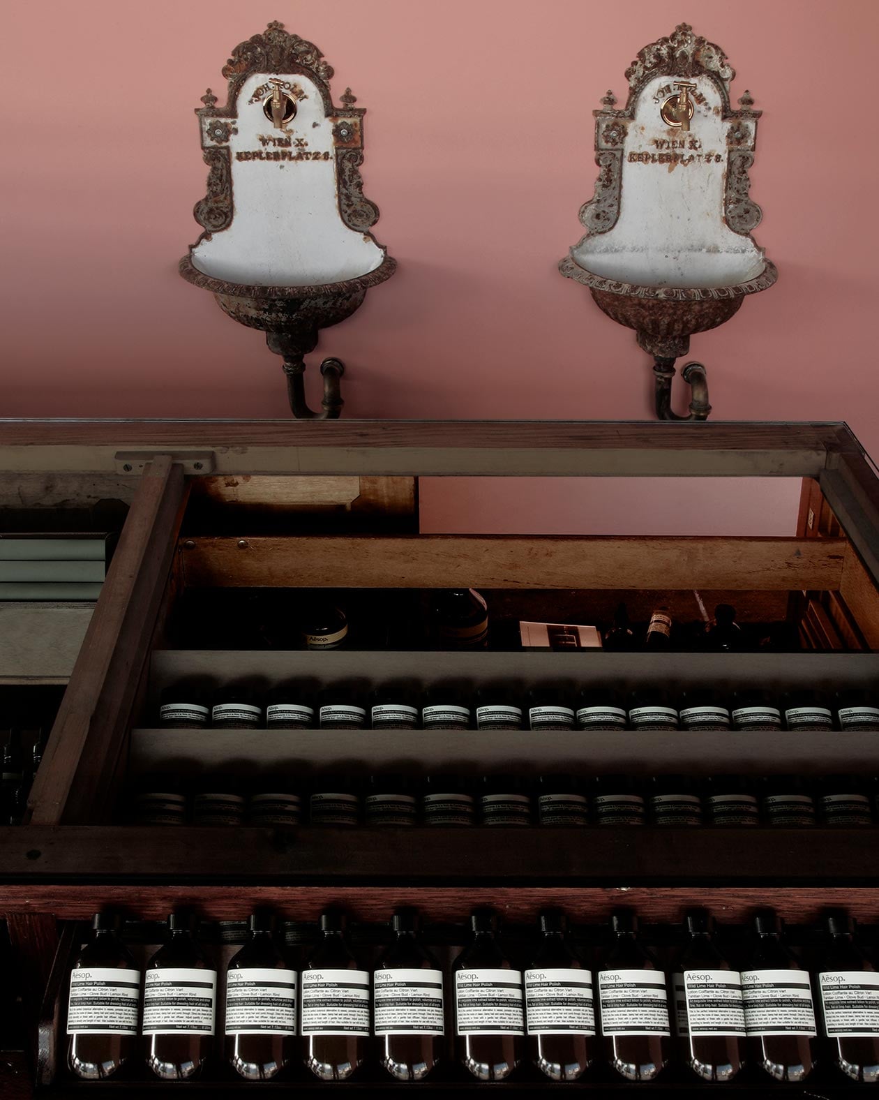 The pale pink wall hosts the vintage Viennese fixtures.