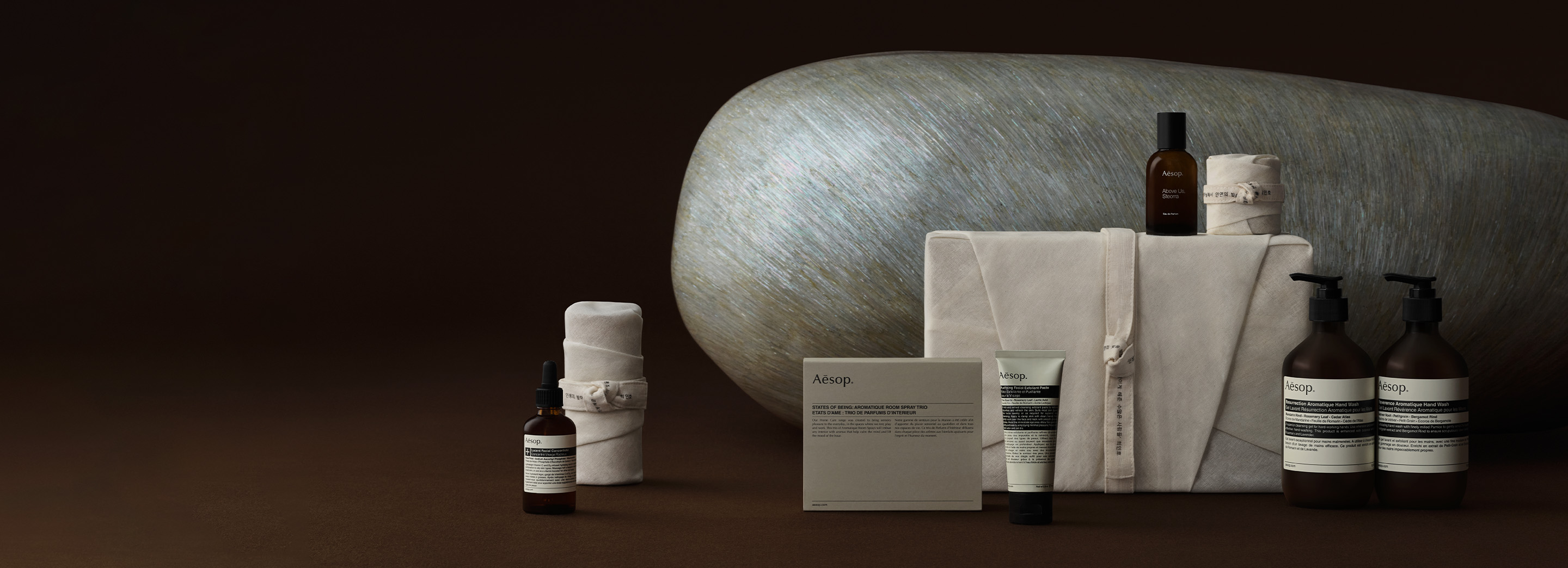 A large Mother-of-pearl art piece behind Aesop products, alongside bojagi gift wrapping.
