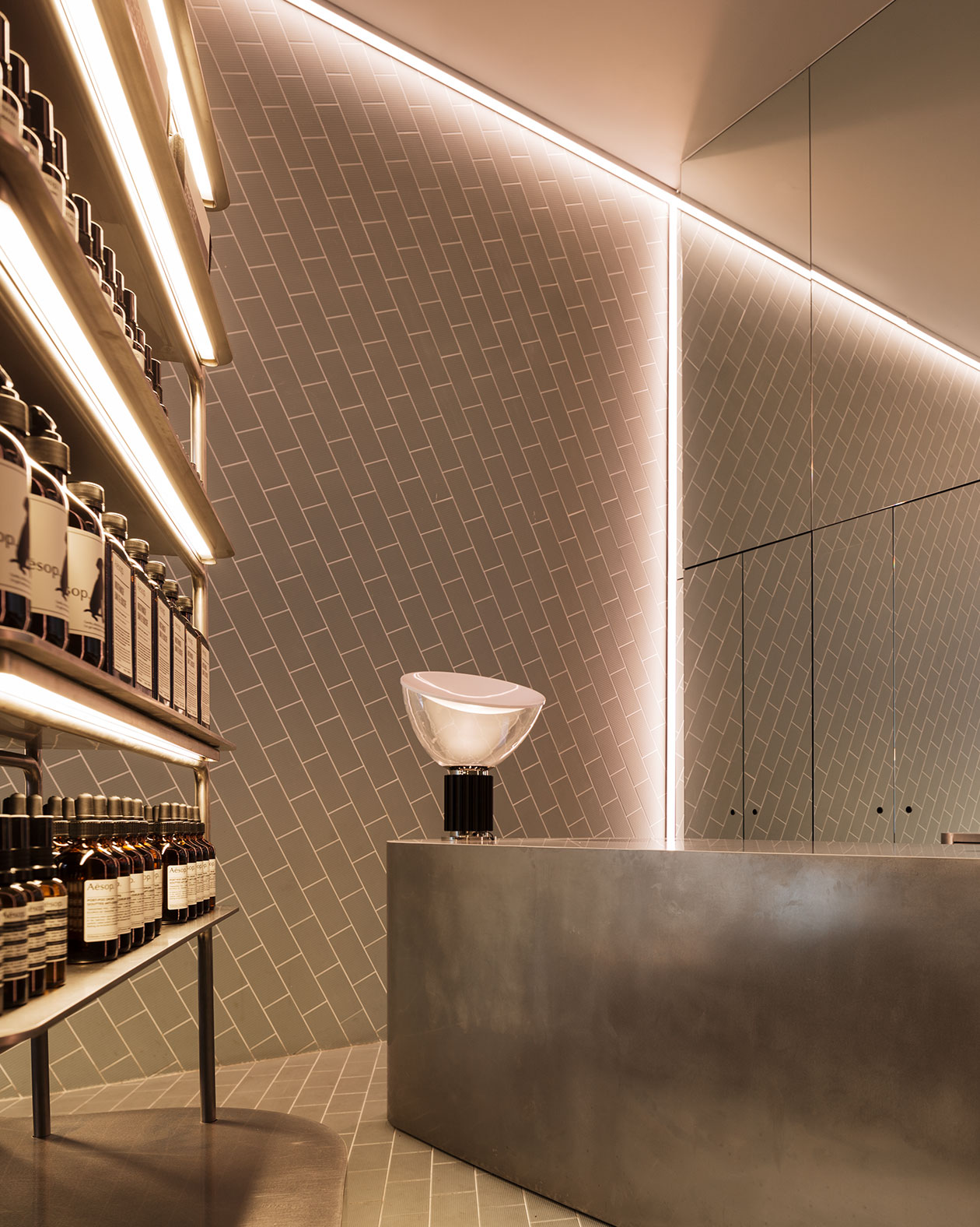 Brushed steel customer service counter with a modern lamp.