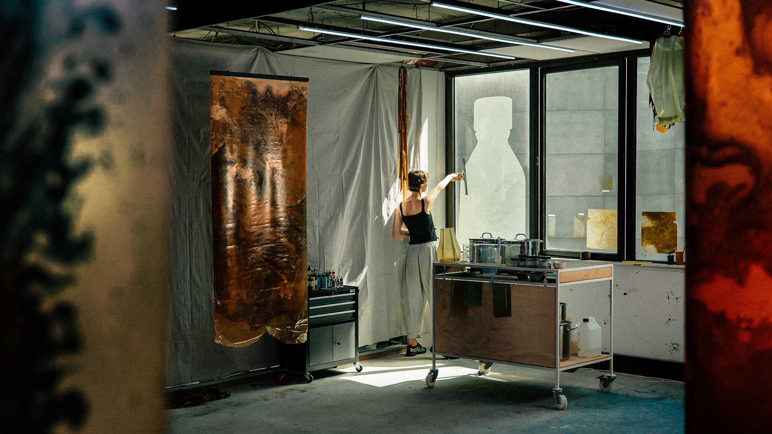 Jessie French placing her artwork on a window