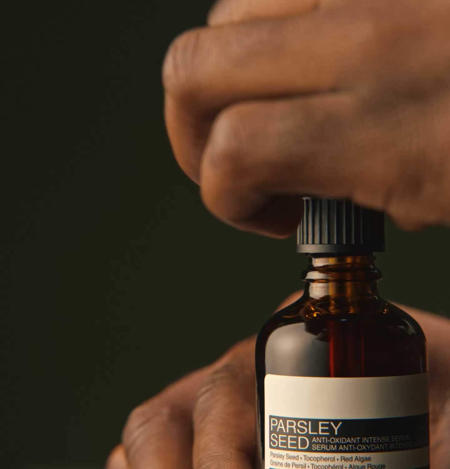Gota de Parsley Seed Anti-Oxidant Intense Serum en una superficie de hormigón.