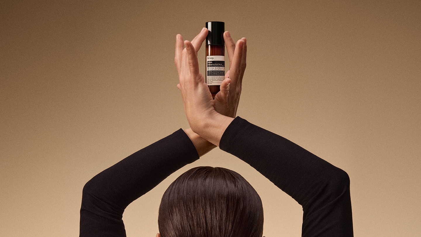 A hand holding the Solais Replenishing Hand Serum