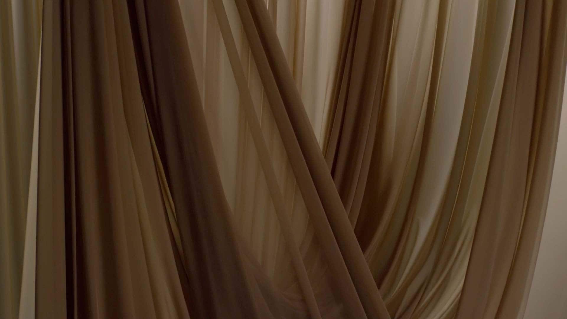 An image of a nude coloured fabric swaying.