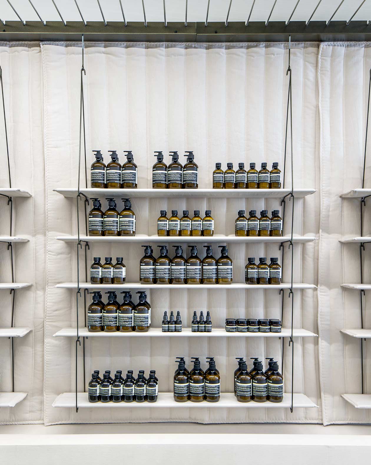 White string shelving holding Aesop product.